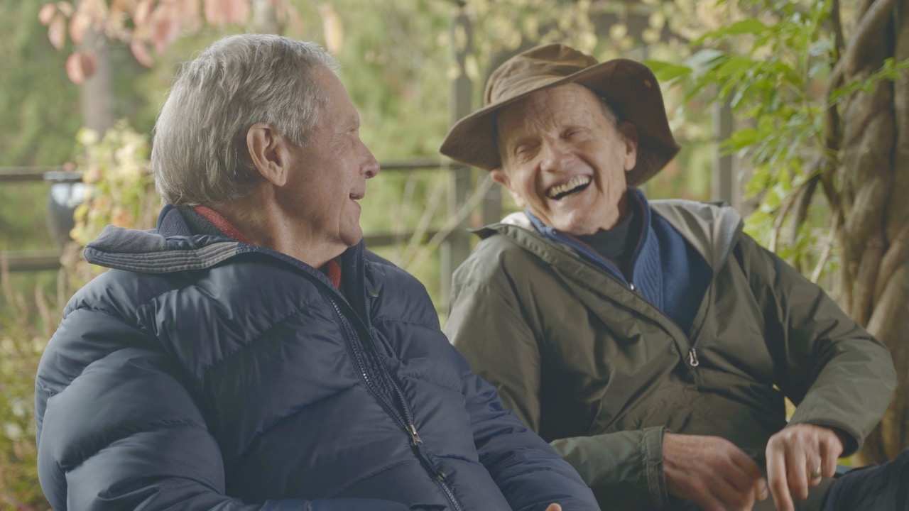 two men sitting together and laughing